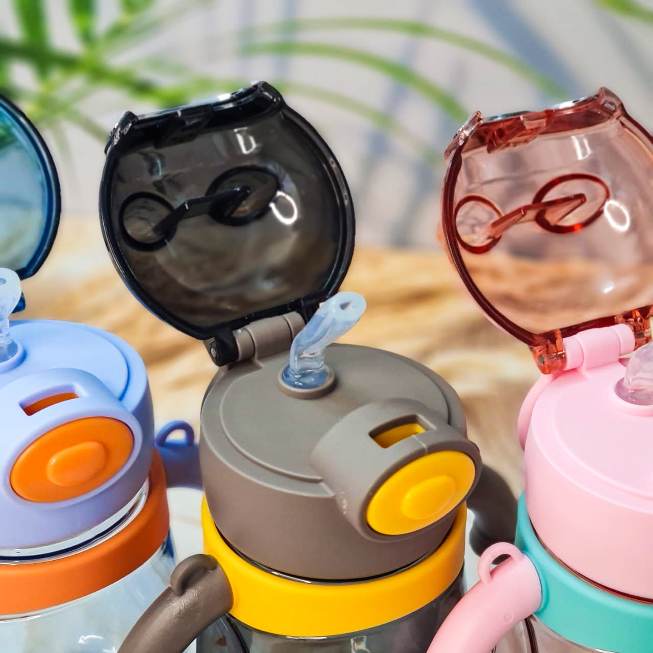 Three plastic water bottles designed with bear motifs, each with a carrying strap and handles in various colors. www.usmile.toys